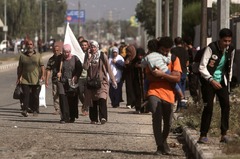 パレスチナ自治区ガザ地区の南部へと避難するなか、白い旗を掲げる女性＝１１月７日
