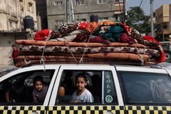 家財を積んだ車の中に座る子どもたち＝１０月２８日、パレスチナ自治区ガザ地区ハンユニス