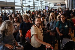 ベングリオン空港で予約した飛行機への搭乗を待つ人々＝１０月１０日