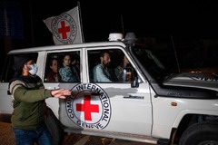 解放されたイスラエル人の人質を運んでラファ検問所に入る赤十字の車両＝１１月２５日