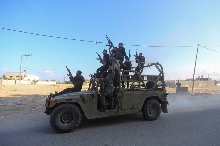 １０月７日、イスラエル南部に侵入し同国軍の車両を奪い移動するパレスチナ人の戦闘員/Ahmed Zakot/Reuters