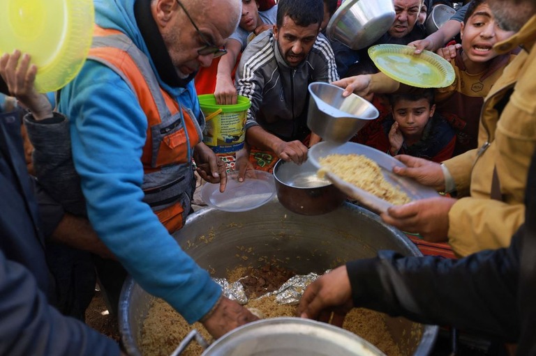 住居を失い、ガザ南部での食料の提供に群がる人々/Mohammed Abed/AFP/Getty Images