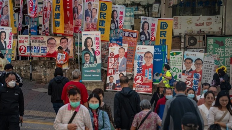 区議選立候補者らの幟の前を行き交う香港の住民/Vernon Yuen/NurPhoto/Getty Images