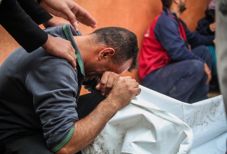 死亡したパレスチナ人の遺体を引き取った人＝１３日、パレスチナ自治区ガザ地区ハンユニス/Ahmad Hasaballah/Getty Images