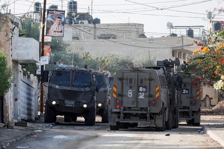 ジェニンでの急襲作戦で路上を移動するイスラエル軍車両＝１２日/Raneen Sawafta/Reuters