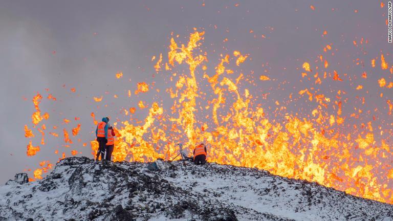 噴火口に立ち、噴火の測定やサンプル採取を行うアイスランド大学の科学者ら/Marco Di Marco/AP