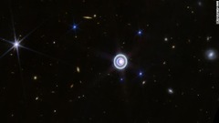 光り輝く天王星の画像。多数の輪や衛星も見える