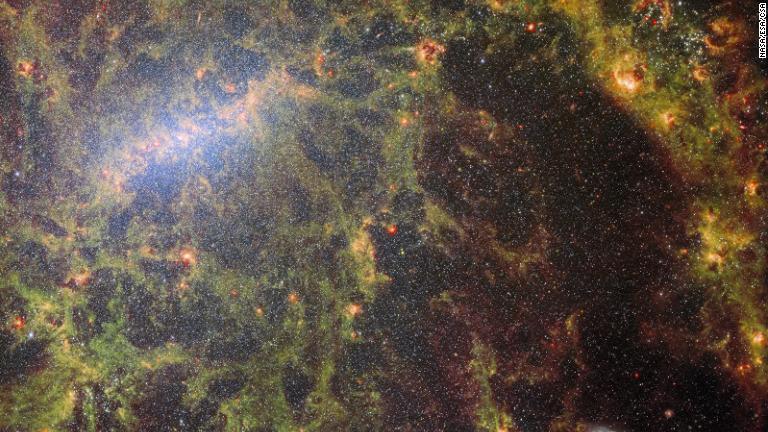 ウェッブ望遠鏡の中間赤外線装置「ＭＩＲＩ」と近赤外線カメラ「ＮＩＲＣａｍ」で撮影された合成画像。棒渦巻銀河「ＮＧＣ５０６８」の恒星やちりを捉えている/NASA/ESA/CSA