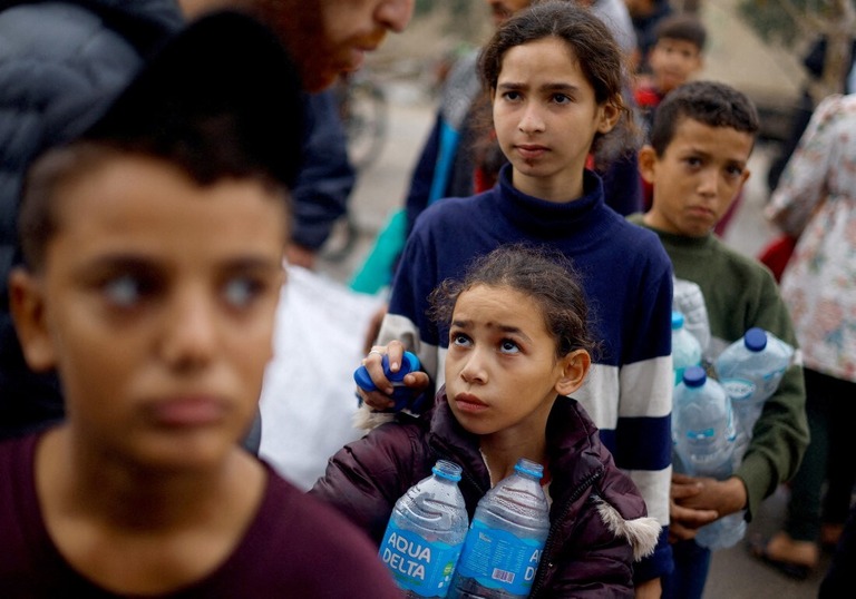 空のボトルを手に水汲みの列に並ぶパレスチナ人の子どもたち＝５日、パレスチナ自治区ガザ地区ラファ/Mohammed Salem/Reuters