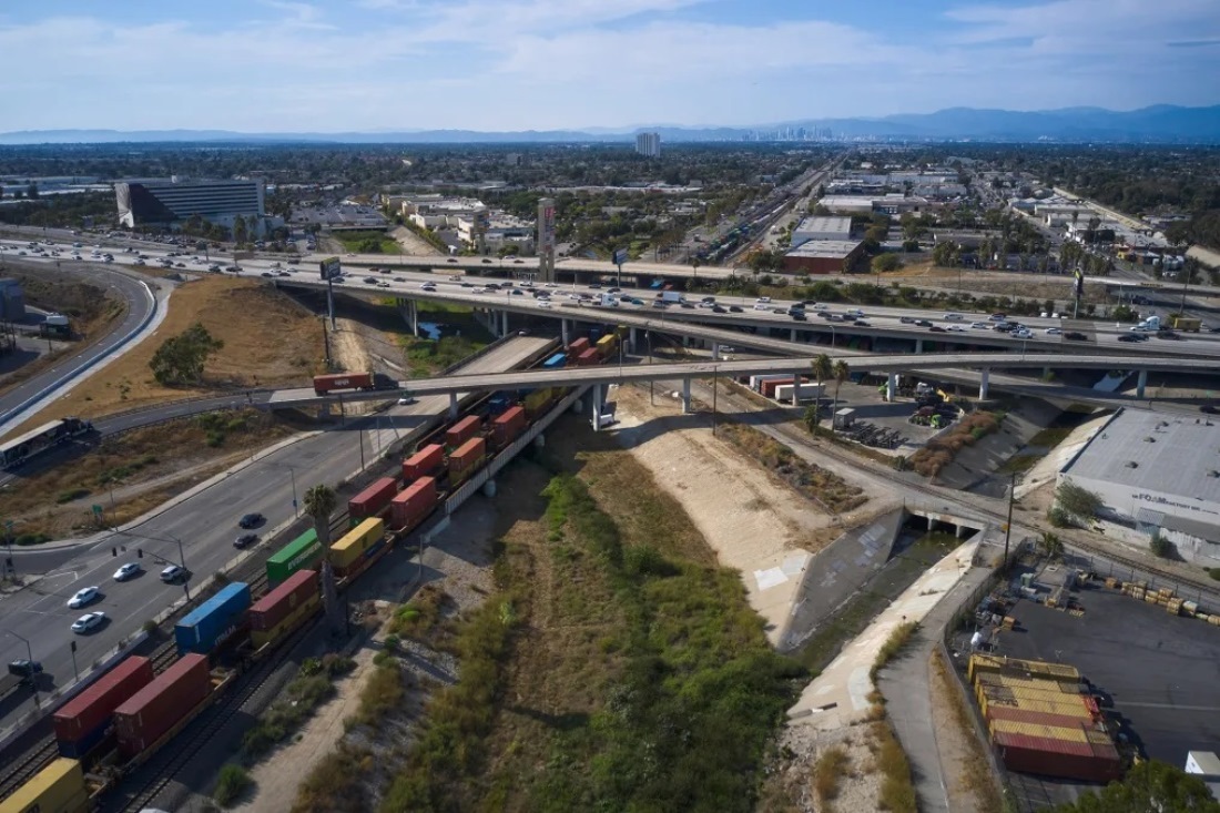 貨物列車の長い列が、カリフォルニア州の高速道路の下を走行する/Bing Guan/Bloomberg/Getty Images