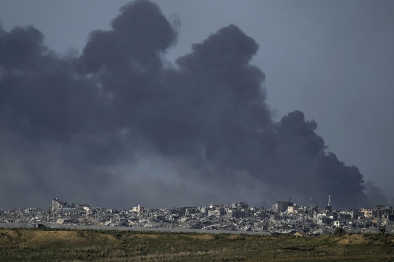 イスラエルの爆撃後に煙が立ち上る様子（イスラエル南部から見た光景）＝２６日/Leo Correa/AP