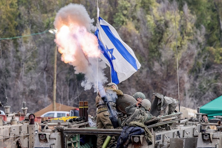 イスラエル南部の境界沿いで装甲車両から迫撃砲を発射し耳を押さえるイスラエル軍兵士＝３日/Jack Guez/AFP/Getty Images