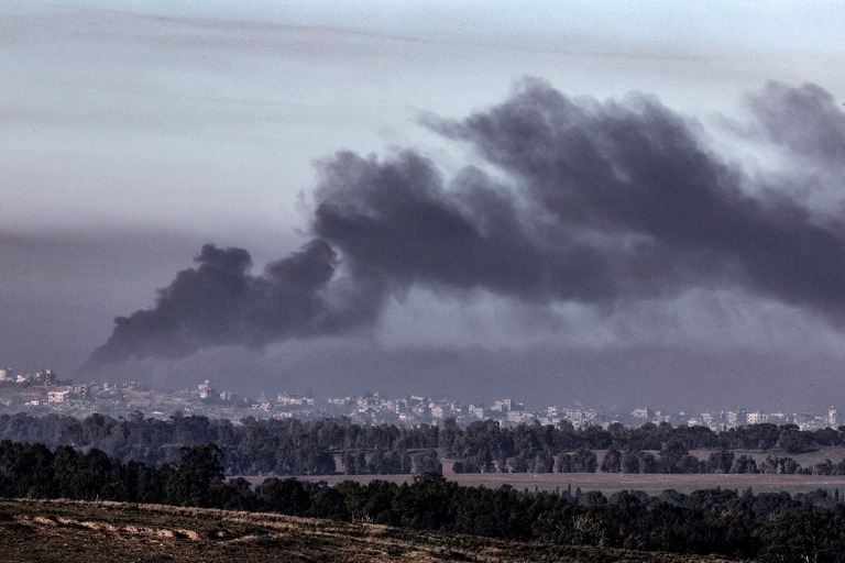 イスラエル南部のガザ地区との境界沿いから撮影。イスラエル軍による爆撃の中黒煙が上がる＝４日/Jack Guez/AFP/Getty Images