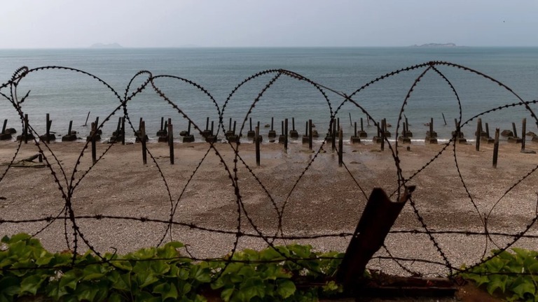 延坪島（ヨンピョンド）のビーチ沿いに設置された有刺鉄線/SeongJoon Cho/Bloomberg/Getty Images