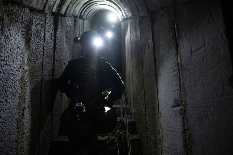 記者に地下トンネルを案内するイスラエル軍兵士。軍はここに人質が拘束されていた証拠を見つけたと主張する＝１０日、ハンユニス/Ohad Zwigenberg/AP
