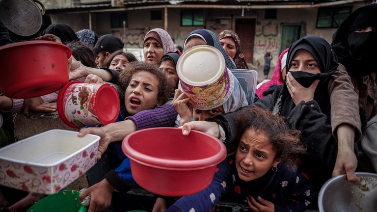 ガザ南部ラファの難民キャンプで食糧の支給を待つパレスチナ人ら/Saher Alghorra/Middle East Images/AFP/Getty Images