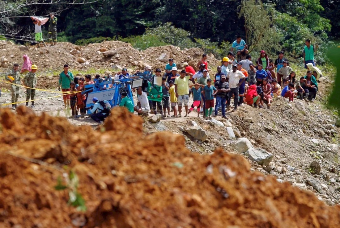 土砂崩れが発生した場所で救助作業を見守る住民ら＝１３日/Fredy Builes/AFP/Getty Images
