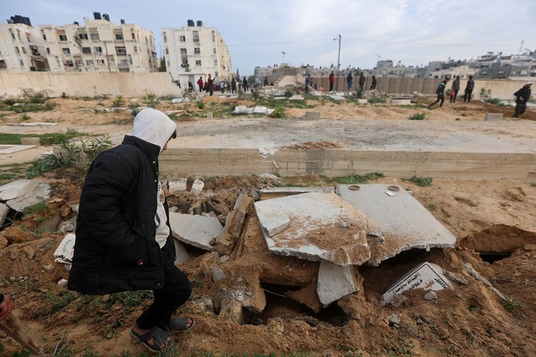 イスラエル軍による攻撃で破壊された墓地を確認するパレスチナ人＝１７日、ガザ地区南部ハンユニス/Ahmed Zakot/Reuters