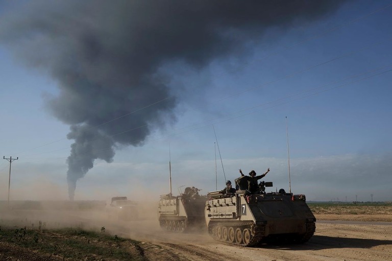 ２１日、イスラエルとガザ地区の境界近くを移動するイスラエル軍の兵士ら/Leo Correa/AP