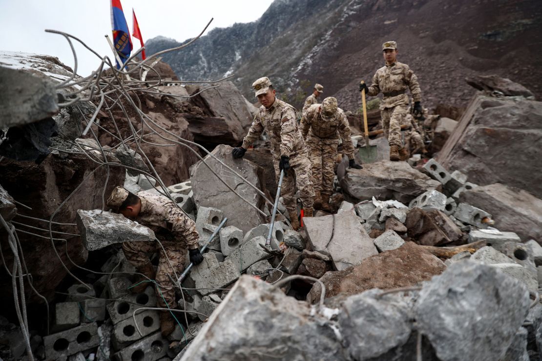 がれきの間で生存者を探す中国軍の兵士/AFP/Getty Images