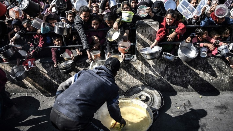 ガザ地区南部ラファで、慈善団体の配給する食料を待つパレスチナの人々/Abed Zagout/Anadolu/Getty Images