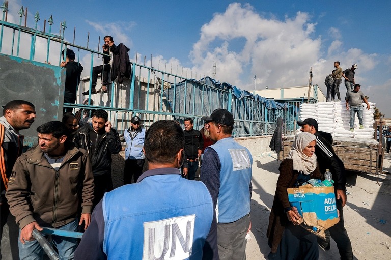 支援物資を配布する国連パレスチナ難民救済事業機関（ＵＮＲＷＡ）の職員＝２０２３年１２月、パレスチナ自治区ガザ地区ラファ/Mohammed Abed/AFP/Getty Images