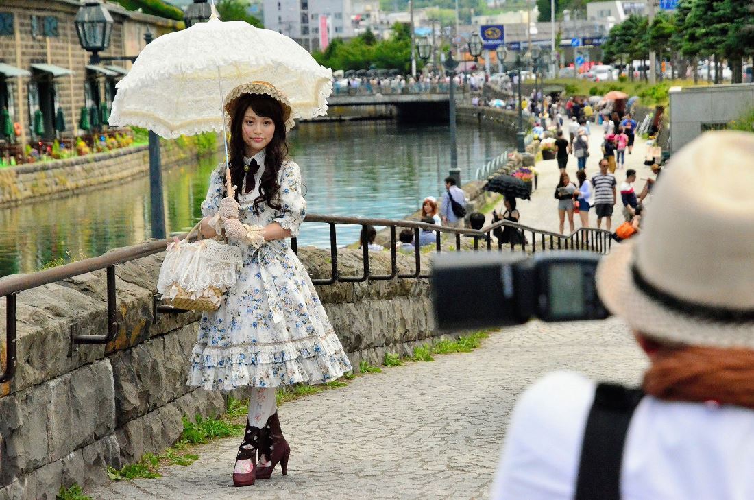 小樽運河をバックにした記念撮影でポーズをとるロリータファッションの女性/The Asahi Shimbun/Getty Images