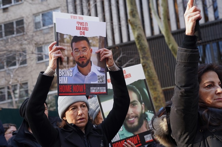 集会でイスラエル人の人質が写ったポスターを掲げる女性＝１２日、米ニューヨーク・マンハッタン/Derek French/SOPA Images/Shutterstock