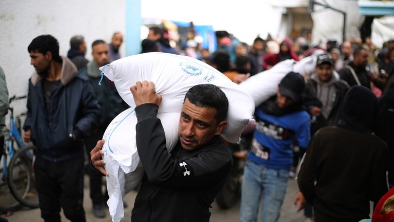 ガザ南部ラファで、パレスチナ難民に向けたＵＮＲＷＡからの支援物資をで運ぶ男性/Khaled Omar/Xinhua/Getty Images