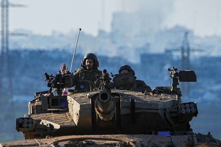 ガザとの境界地域を戦車で移動するイスラエル軍兵士/Ariel Schalit/AP