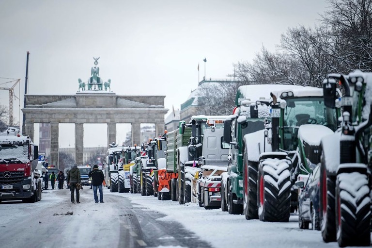 独ベルリンのブランデンブルク門の前にトラクターなどで乗り付けた抗議デモ参加者/Kay Nietfeld/dpa via AP