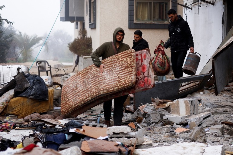 イスラエルによる攻撃を受けた現場の家屋から家財道具を運び出す住民＝９日、ラファ/Ibraheem Abu Mustafa/Reuters