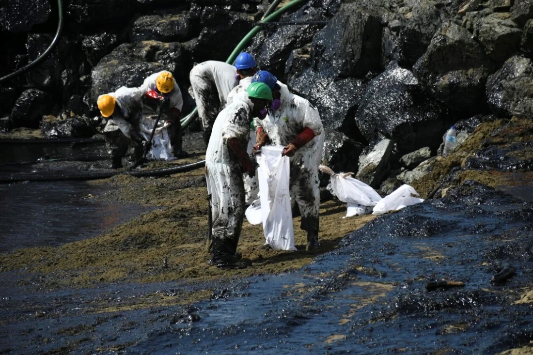 ビーチで油の除去を行う作業員ら＝１０日/Akash Boodan/AP