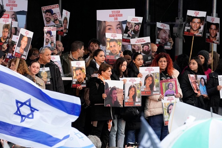 イスラエルの人質の写真を掲げて抗議する人々＝１４日、オランダ・ハーグ/Martin Meissner/AP