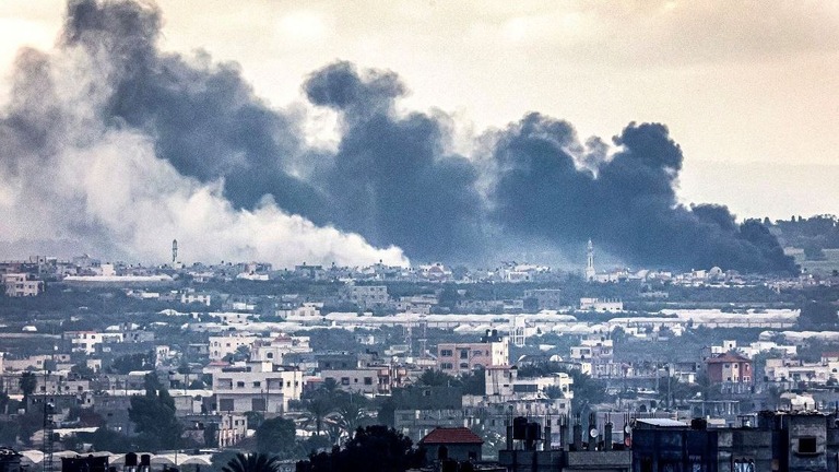 イスラエルによるガザ南部ハンユニスへの爆撃で立ち上る煙をラファから眺める/Said Khatib/AFP/Getty Images
