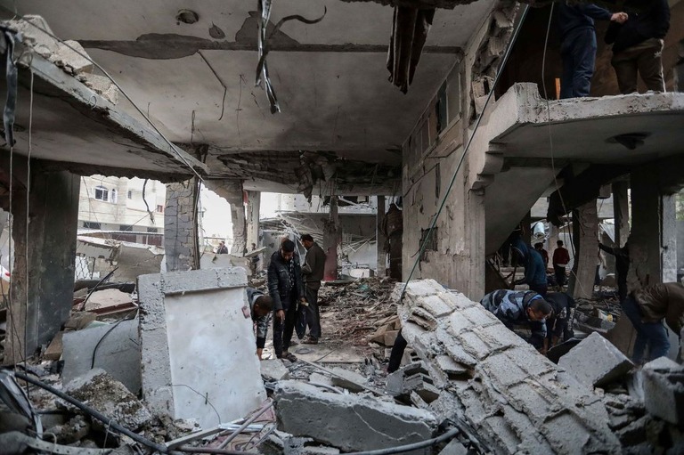 ガザ南部ラファでのイスラエル軍の空爆後、自宅の被害状況を確認する人々/Ahmad Hasaballah/Getty Images via CNN Newsource