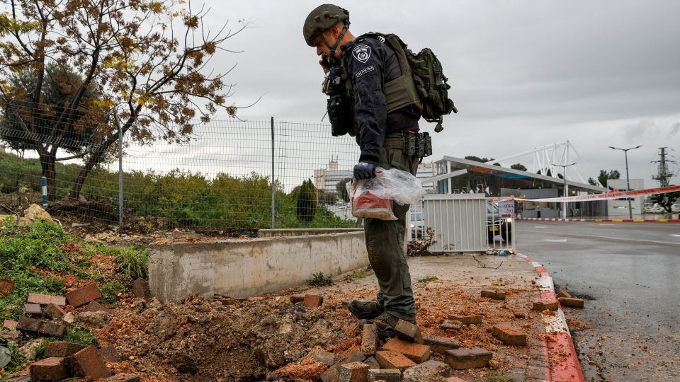 イスラエル警察がレバノン南部から発射されたロケット弾でできた穴を調査=14日、イスラエル北部ツファット/Jalaa Marey/AFP/Getty Images