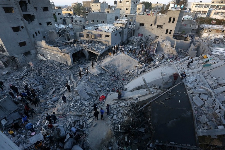 イスラエルによる攻撃後、破壊された建物のがれきの中で捜索・救助活動を行う住民＝２８日、ガザ地区中部デリアルバラ/Ashraf Amra/Anadolu/Getty Images