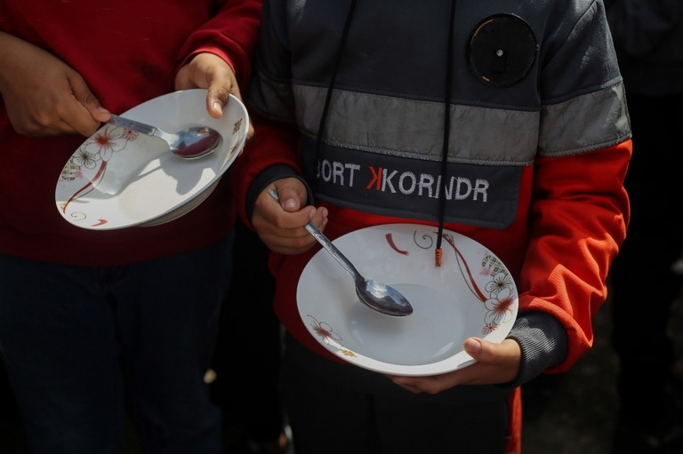 空の食器を手に戦争と飢餓の終結を訴える行進に参加する子どもたち/Ahmad Hasaballah/Getty Images