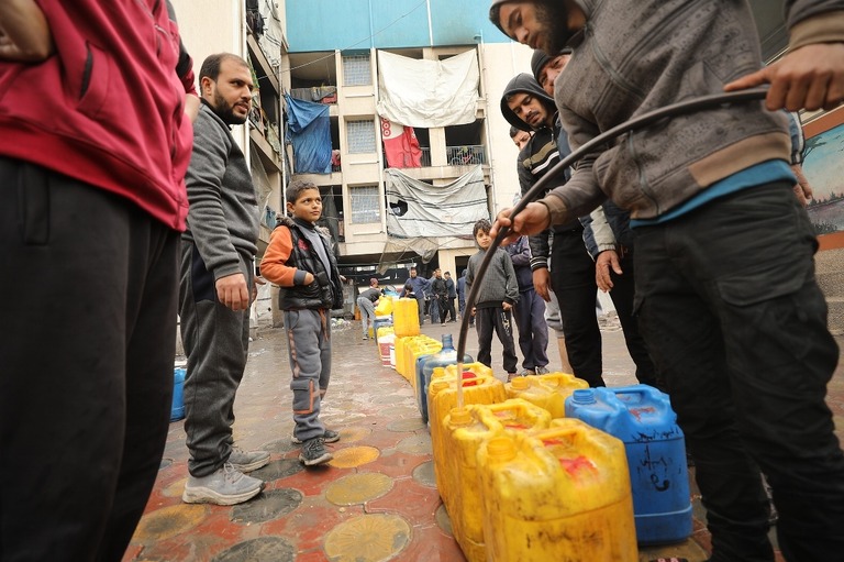 容器に水を入れるパレスチナの人々＝３日、パレスチナ自治区ガザ地区ガザ市/Dawoud Abo Alkas/Anadolu via Getty Images