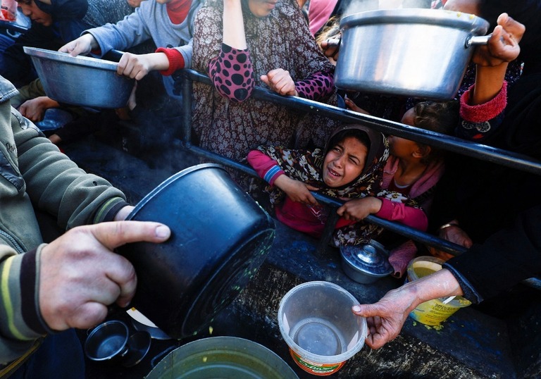 食料の配給を待つパレスチナの子どもら＝１３日、パレスチナ自治区ガザ地区南部ラファ/Mohammed Salem/Reuters