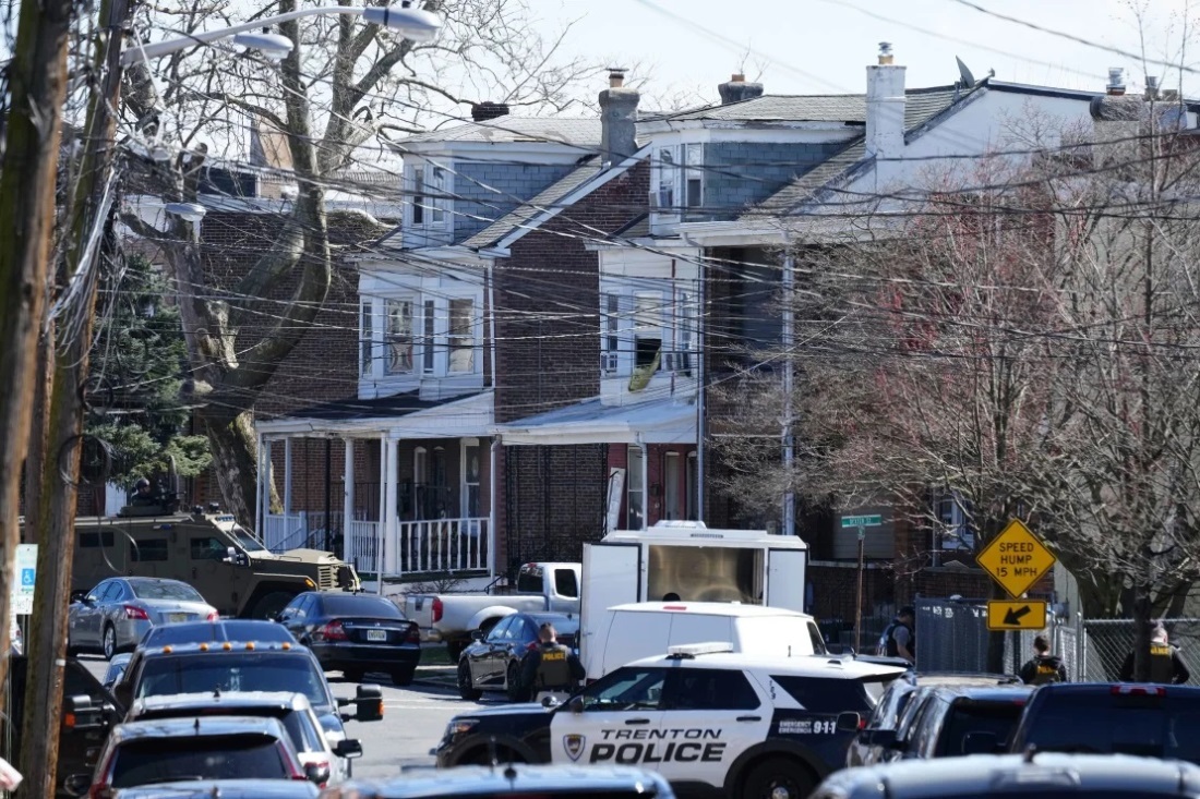 容疑者が立てこもったとみられる住宅を包囲する警察/Matt Rourke/AP