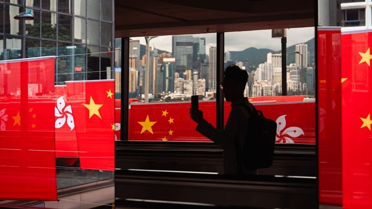 中国と香港の旗を撮影する人＝２０２３年６月２９日、香港/SOPA Images/LightRocket/SOPA Images/LightRocket/Getty Images