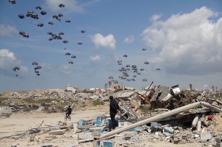 空中投下される支援物資＝２５日、パレスチナ自治区ガザ地区ガザ市/Mahmoud Essa/AP