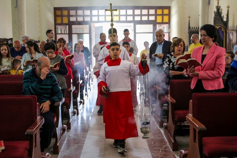 ３１日、ガザ市内の教会でイースター（復活祭）礼拝に参加する人々/AFP/Getty Images