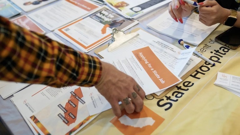 米カリフォルニア州で開催された復員軍人雇用フェアで書類を手にする求職者/Eric Thayer/Bloomberg/Getty Images