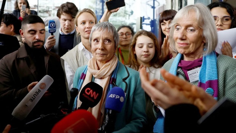 勝訴後にインタビューに応じる気候関係団体の女性２人/Christian Hartmann/Reuters