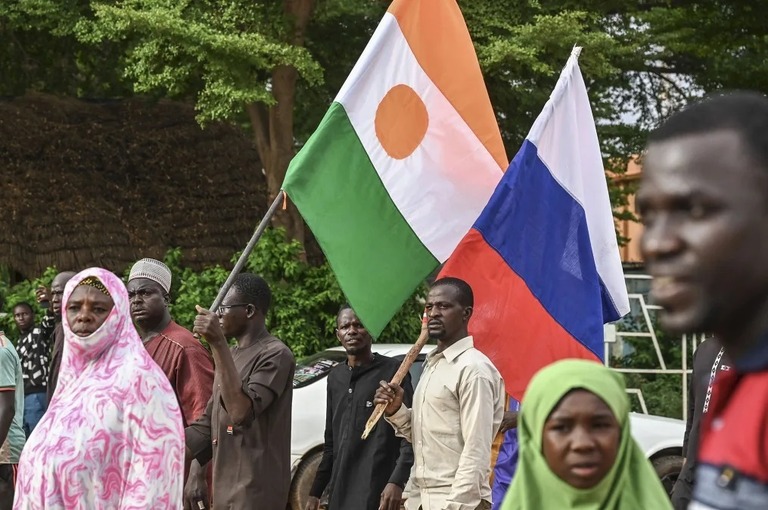 ニジェールとロシアの国旗を掲げるニジェール軍事政権の支持者ら/AFP/Getty Images