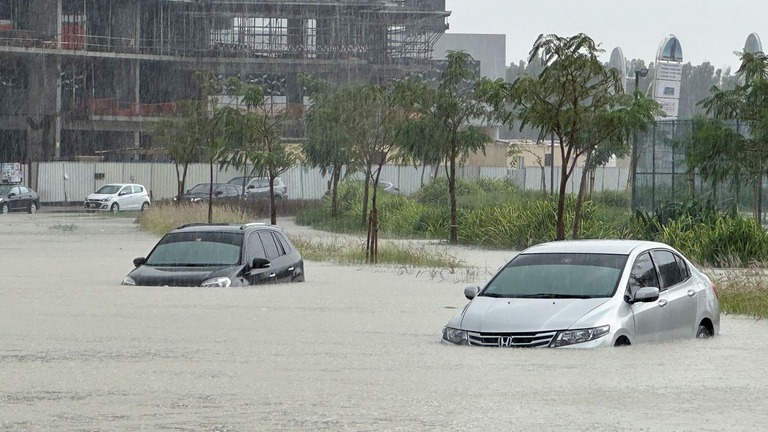 豪雨で川と化したドバイの道路で、濁流にのまれる車両/Abdel Hadi Ramahi/Reuters