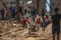 発見された遺体を移送する医療従事者ら＝２３日、パレスチナ自治区ガザ地区南部ハンユニスのナセル病院